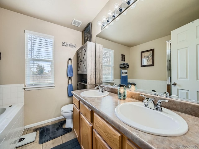 bathroom with a wealth of natural light, vanity, a relaxing tiled tub, and toilet