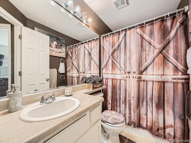 bathroom featuring vanity, a textured ceiling, toilet, and tile patterned floors