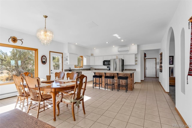 dining space with light tile patterned floors, a wall mounted air conditioner, and an inviting chandelier