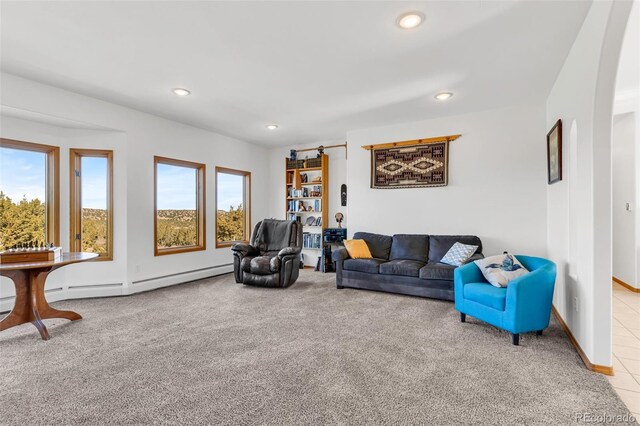 carpeted living room with a wealth of natural light and a baseboard radiator