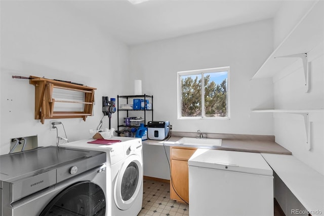 clothes washing area with separate washer and dryer and sink