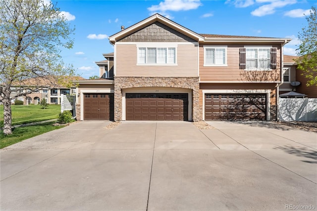 view of front facade with driveway, stone siding, and an attached garage