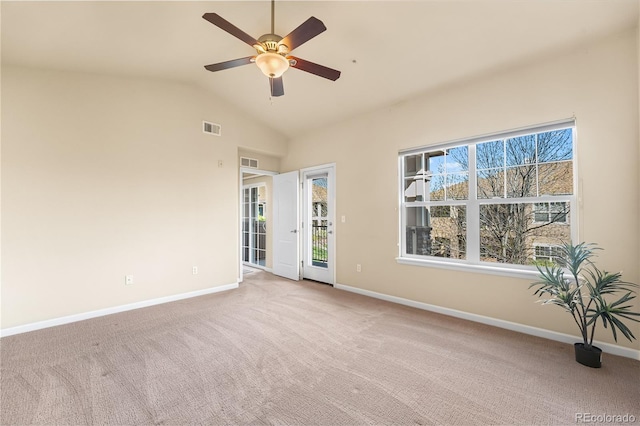 spare room with ceiling fan, light colored carpet, baseboards, and vaulted ceiling