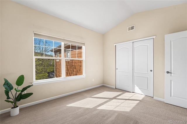 unfurnished bedroom with vaulted ceiling, carpet flooring, baseboards, and a closet