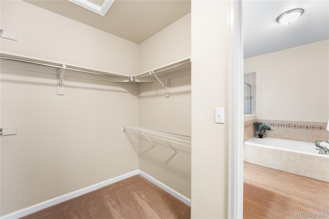 walk in closet with wood finished floors