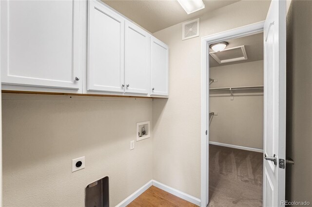 washroom with cabinet space, washer hookup, hookup for an electric dryer, and baseboards