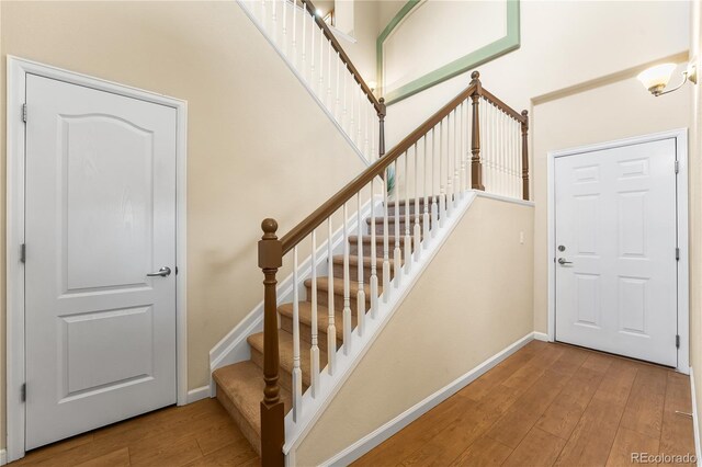 entryway with hardwood / wood-style floors, stairs, and baseboards