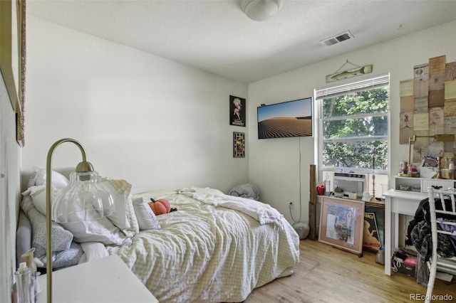 bedroom with light hardwood / wood-style flooring and cooling unit