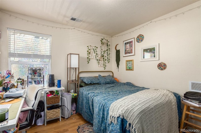 bedroom featuring a textured ceiling and hardwood / wood-style flooring