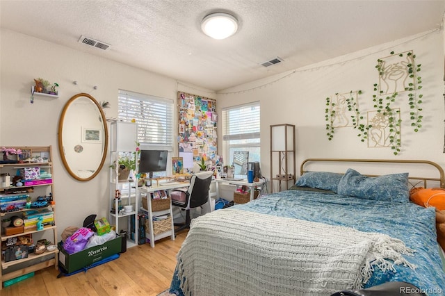 bedroom featuring light hardwood / wood-style floors and a textured ceiling