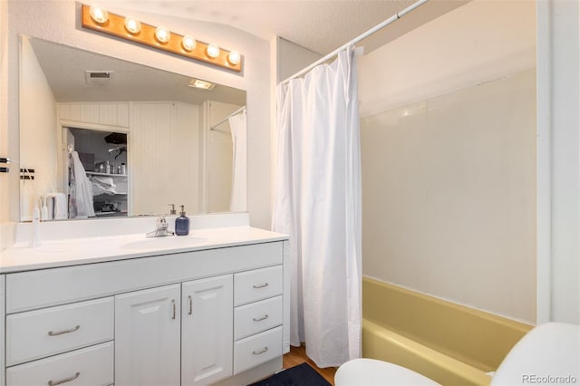 full bathroom featuring shower / bath combination with curtain, vanity, a textured ceiling, vaulted ceiling, and toilet