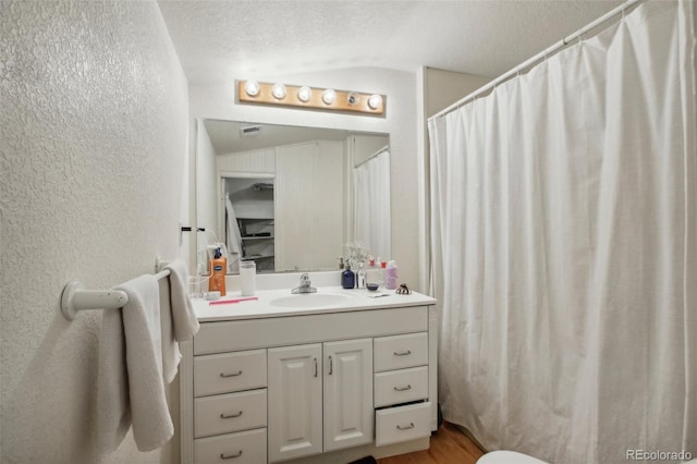 bathroom with vanity, hardwood / wood-style floors, a textured ceiling, and curtained shower