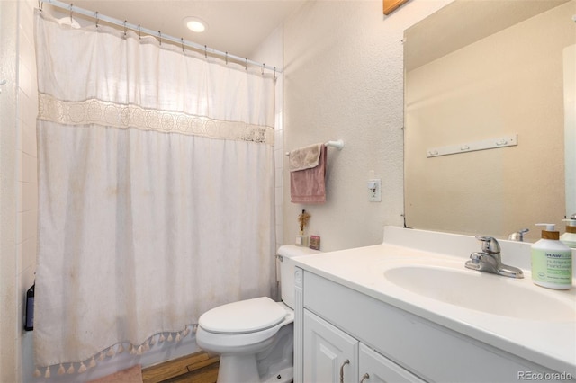 bathroom featuring curtained shower, vanity, and toilet