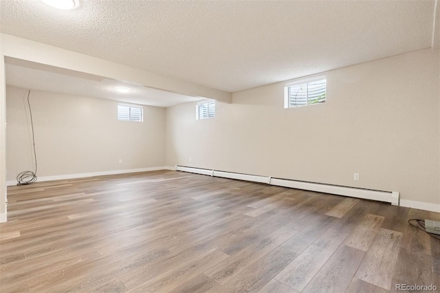1931 Foothills Rd, Golden, CO 80401 - basement featuring wood finished floors, a baseboard heating unit, a textured ceiling, and baseboards
