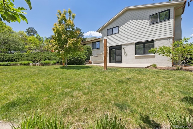 1931 Foothills Rd, Golden, CO 80401 - rear view of property featuring brick siding, a yard, and a patio