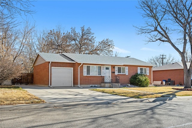 ranch-style house with a garage, fence, brick siding, and driveway