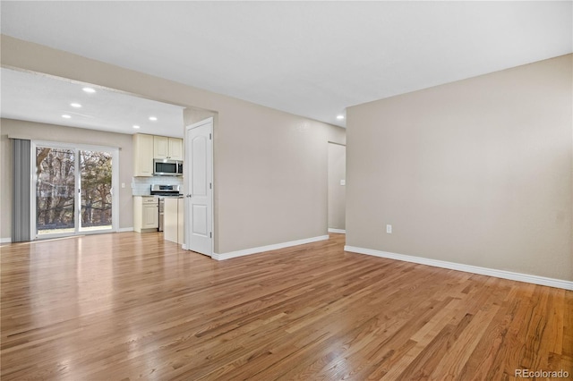 unfurnished living room featuring recessed lighting, baseboards, and light wood-type flooring