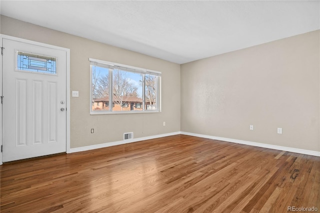 foyer featuring wood finished floors, visible vents, and baseboards