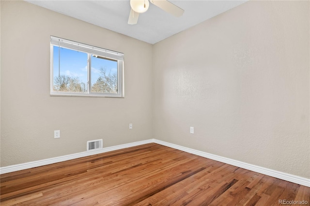 unfurnished room with visible vents, baseboards, ceiling fan, and wood finished floors