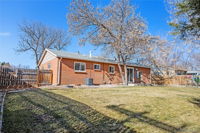 back of house with a yard, central air condition unit, brick siding, and fence