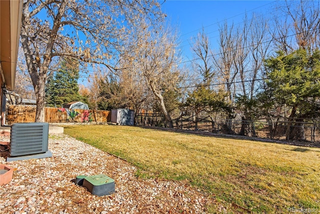 view of yard featuring central AC unit and fence