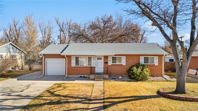 single story home with brick siding, a front lawn, fence, concrete driveway, and a garage