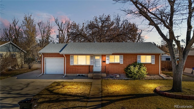 ranch-style house with a front lawn, fence, concrete driveway, a garage, and brick siding