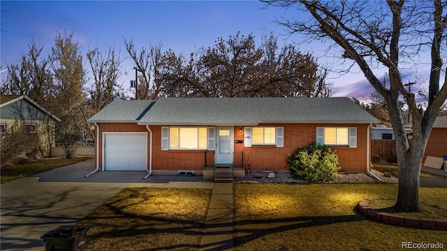 ranch-style house with fence, a shingled roof, concrete driveway, a garage, and brick siding