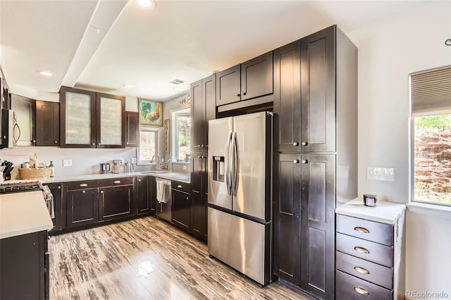 220 Wark Ave, Berthoud, CO 80513 - kitchen with stainless steel appliances, light wood-type flooring, light countertops, recessed lighting, and glass insert cabinets