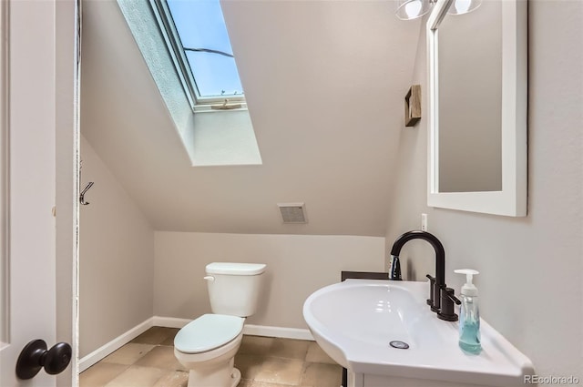 220 Wark Ave, Berthoud, CO 80513 - half bathroom with a skylight, toilet, a sink, baseboards, and vaulted ceiling