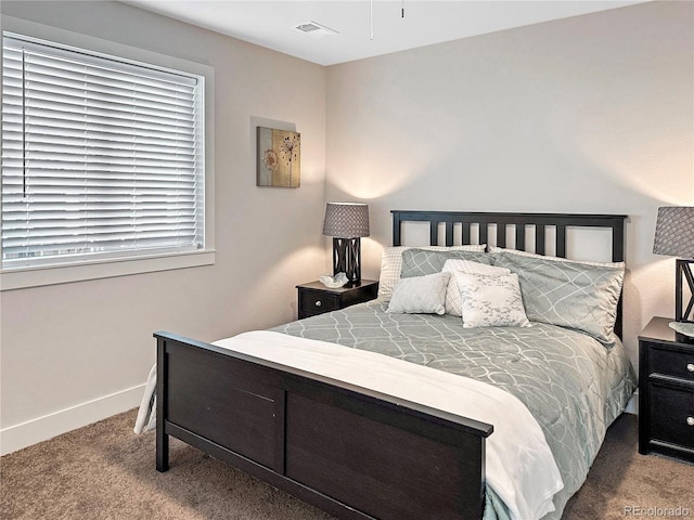 carpeted bedroom featuring baseboards and visible vents