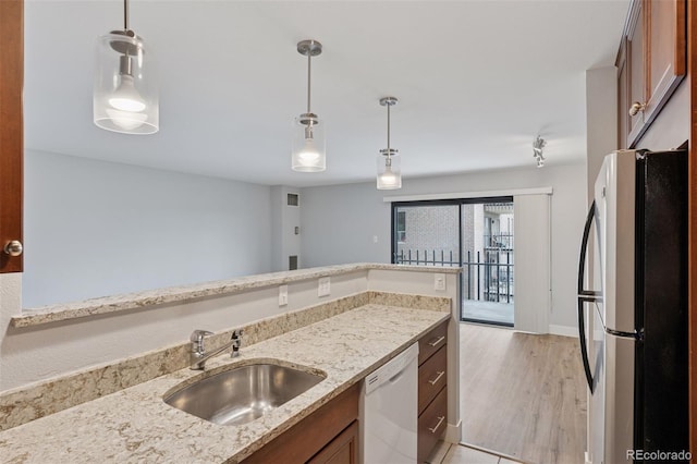 480 S Marion Pkwy Unit 802, Denver, CO 80209 - kitchen featuring freestanding refrigerator, white dishwasher, a sink, brown cabinetry, and light stone counters