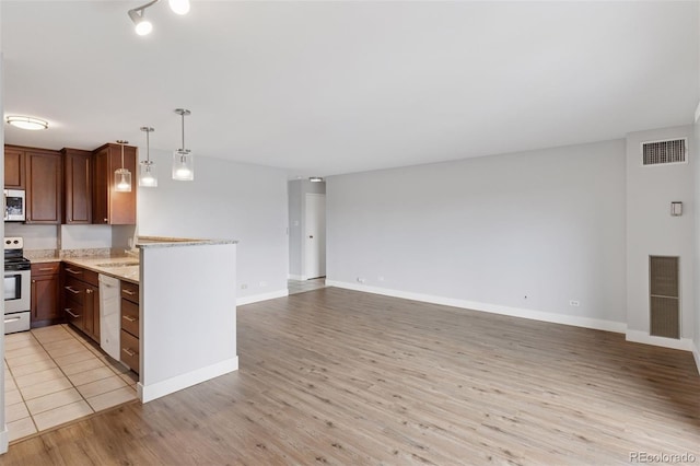 480 S Marion Pkwy Unit 802, Denver, CO 80209 - kitchen with stainless steel appliances, light wood-style floors, open floor plan, light stone counters, and a peninsula