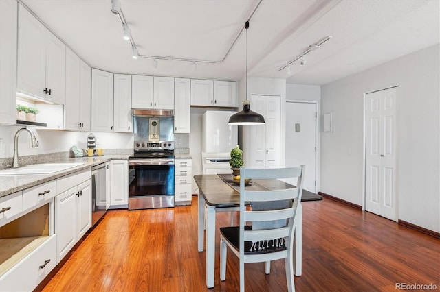 3465 S Poplar St Unit 506, Denver, CO 80224 - kitchen featuring appliances with stainless steel finishes, rail lighting, white cabinets, and light wood-style floors