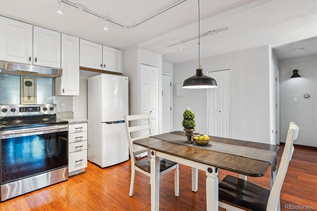 3465 S Poplar St Unit 506, Denver, CO 80224 - kitchen with stainless steel range with electric stovetop, freestanding refrigerator, rail lighting, and under cabinet range hood