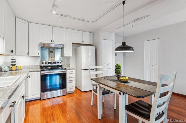 3465 S Poplar St Unit 506, Denver, CO 80224 - kitchen featuring stainless steel range with electric cooktop, freestanding refrigerator, rail lighting, white cabinets, and light countertops