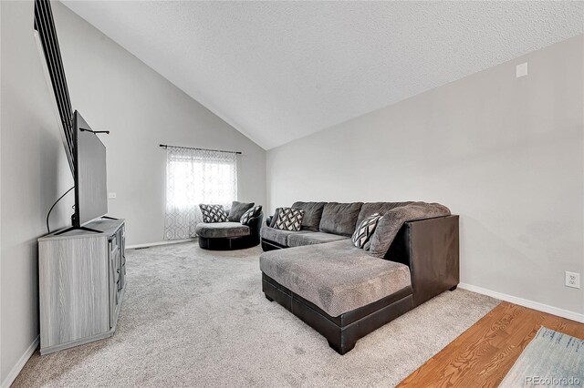 living room with hardwood / wood-style floors, a textured ceiling, and vaulted ceiling