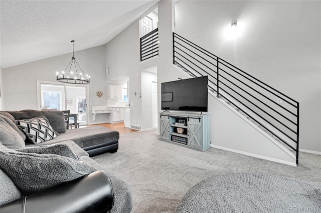 living room with a chandelier, a textured ceiling, carpet floors, and high vaulted ceiling