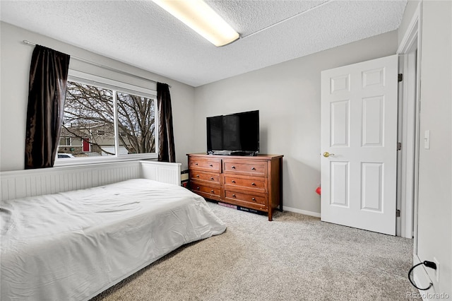 bedroom with light colored carpet and a textured ceiling