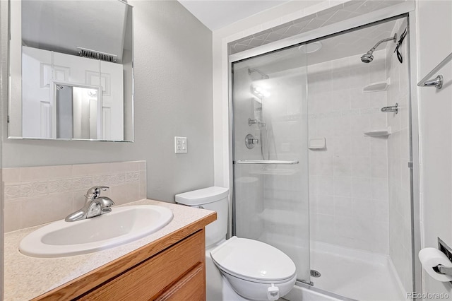 bathroom with backsplash, toilet, vanity, and walk in shower