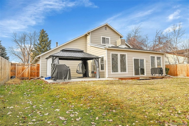 rear view of house featuring a gazebo, a patio, and a lawn