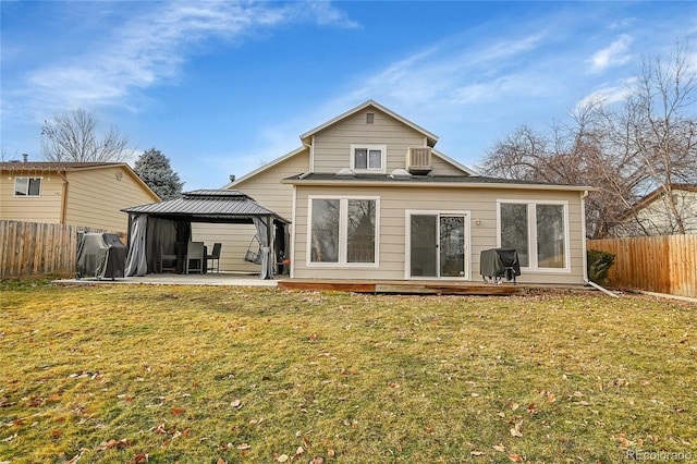 back of property featuring a gazebo and a lawn