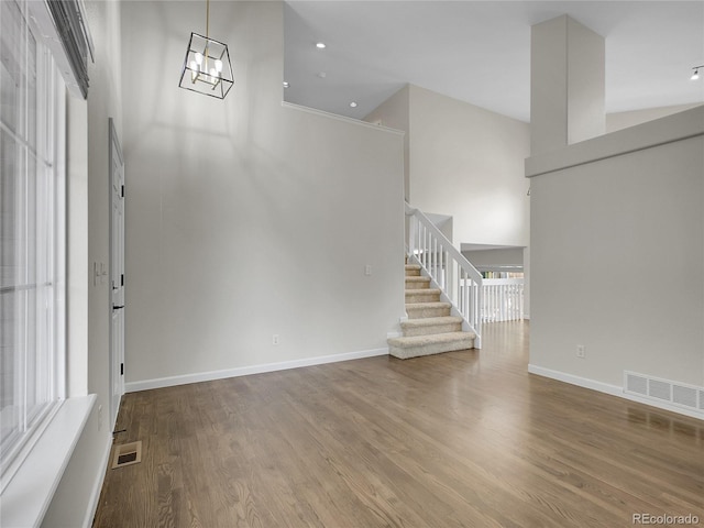 1288 S Beeler Ct, Denver, CO 80247 - entryway featuring stairway, a towering ceiling, wood finished floors, and a chandelier