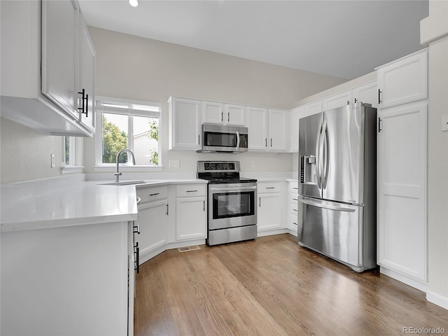 1288 S Beeler Ct, Denver, CO 80247 - kitchen featuring stainless steel appliances, light wood-style floors, white cabinetry, and light countertops