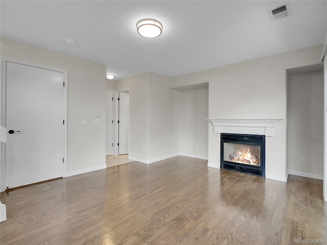 1288 S Beeler Ct, Denver, CO 80247 - unfurnished living room featuring a glass covered fireplace and wood finished floors