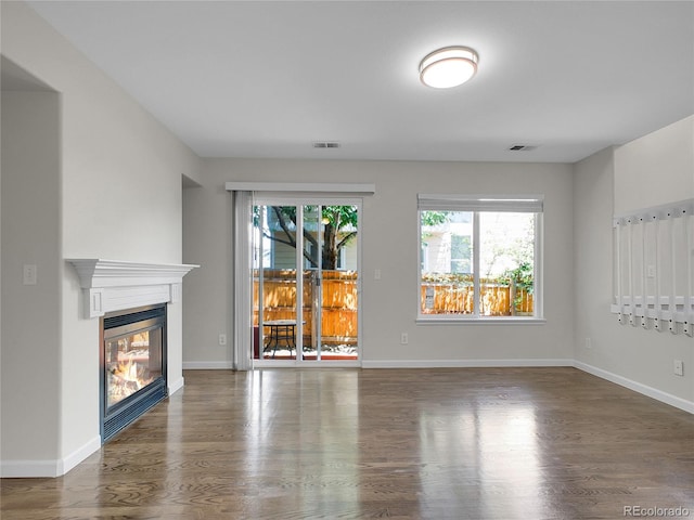 1288 S Beeler Ct, Denver, CO 80247 - unfurnished living room featuring plenty of natural light, wood finished floors, and a glass covered fireplace