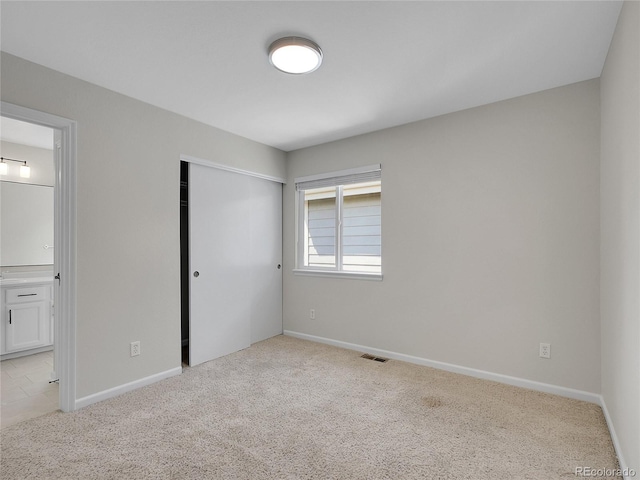 1288 S Beeler Ct, Denver, CO 80247 - unfurnished bedroom featuring light carpet, ensuite bath, and a closet