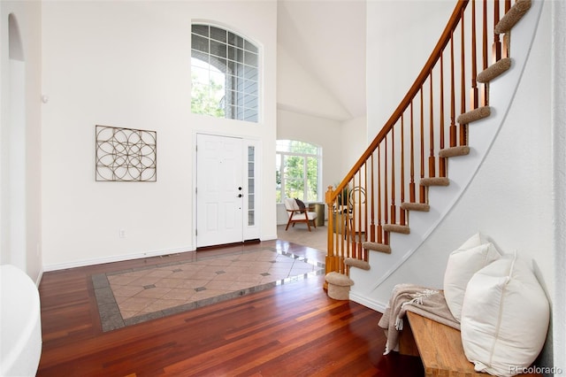 entryway with dark hardwood / wood-style floors and a high ceiling