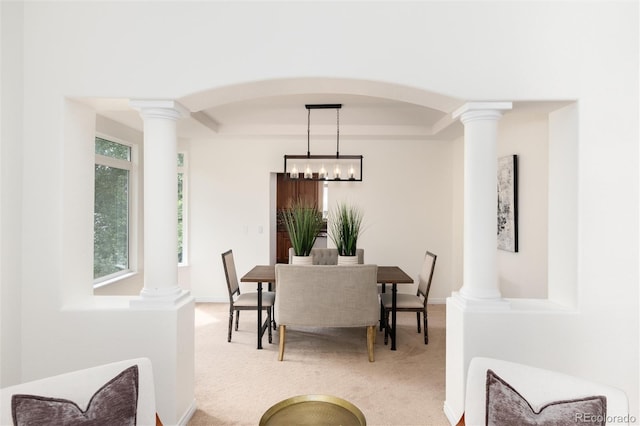 carpeted dining space featuring a tray ceiling and a notable chandelier