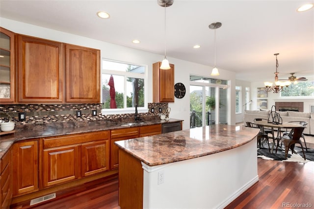 kitchen featuring decorative light fixtures, a center island, and a wealth of natural light